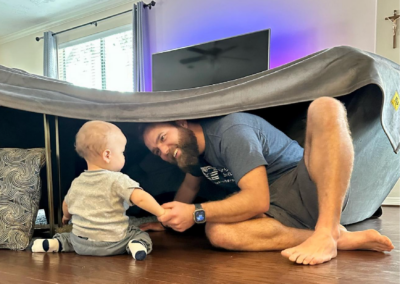 guy and baby under blanket