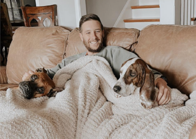 guy with two dogs and blanket on couch